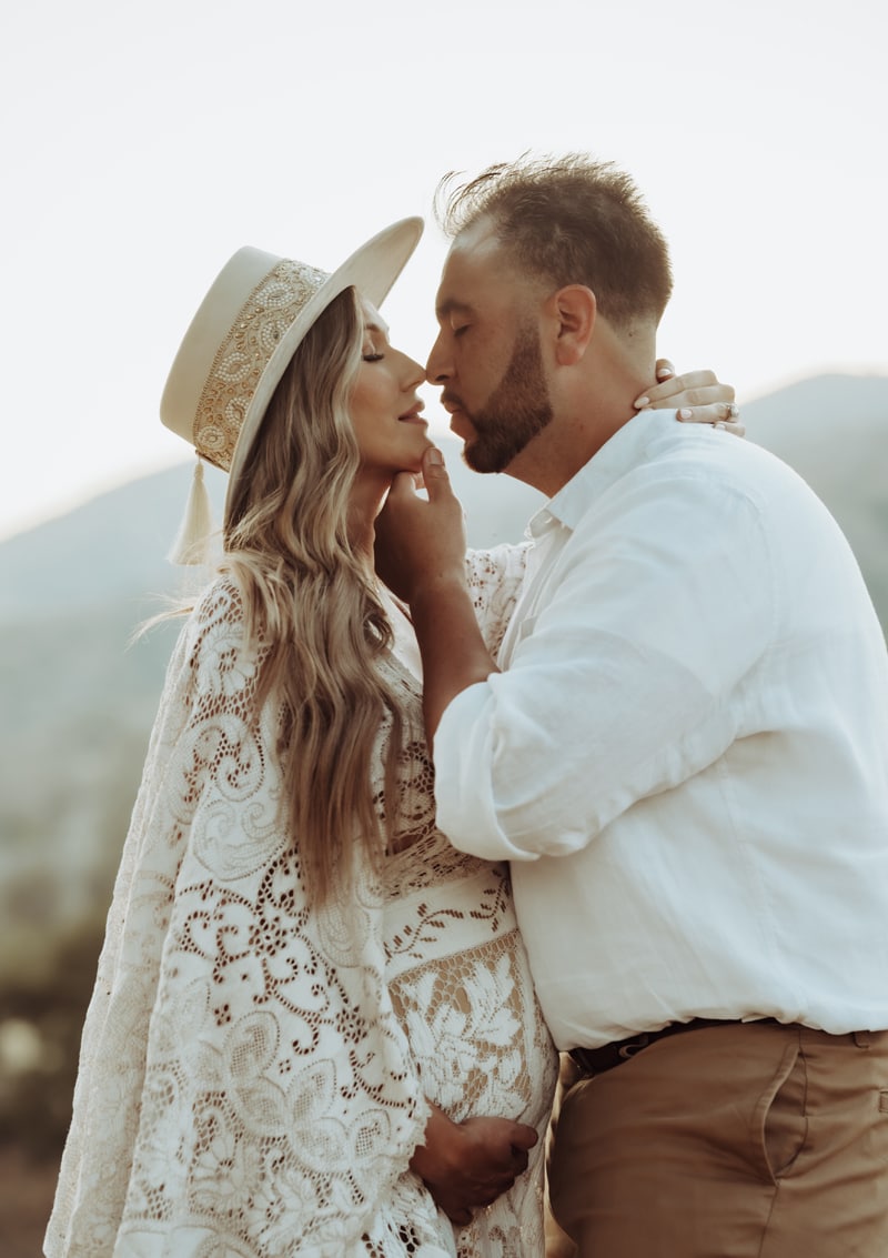 Maternity Photographer, a husband draws in to kiss his expecting wife