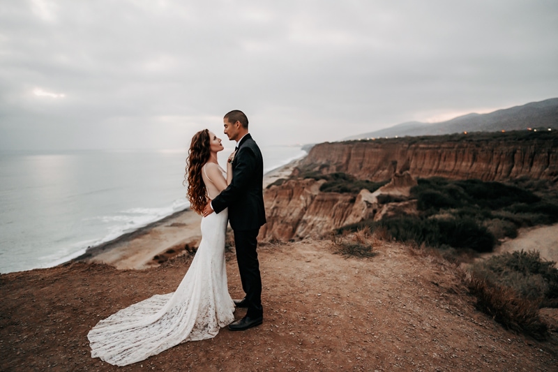 Elopement Photographer, bride and groom hold each other at seaside cliffs