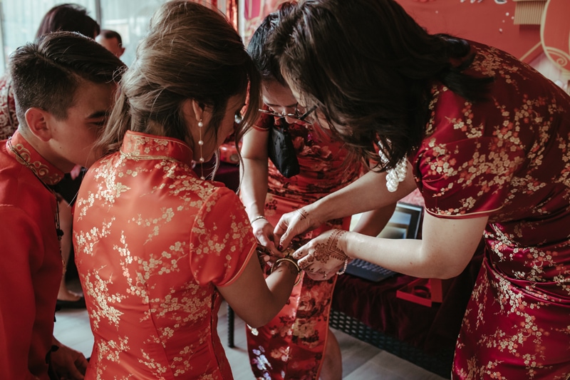 Wedding Photographer, bridesmaids assist each other, they wear dresses with floral patterns