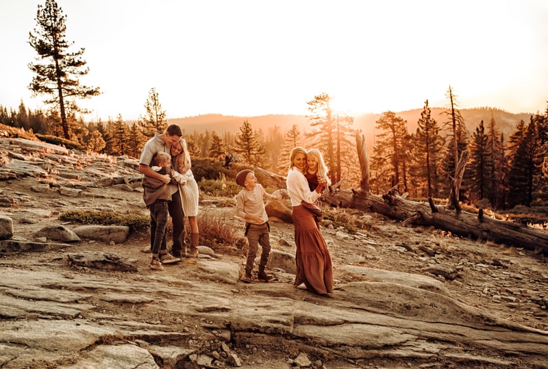 Family Photographer, mom and dad walk in a mountain forest area with their five kids