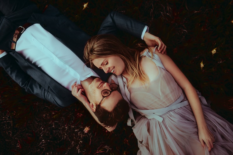 elopement photographer, a man and woman lay side beside in the grass happily gazing into each other's eyes