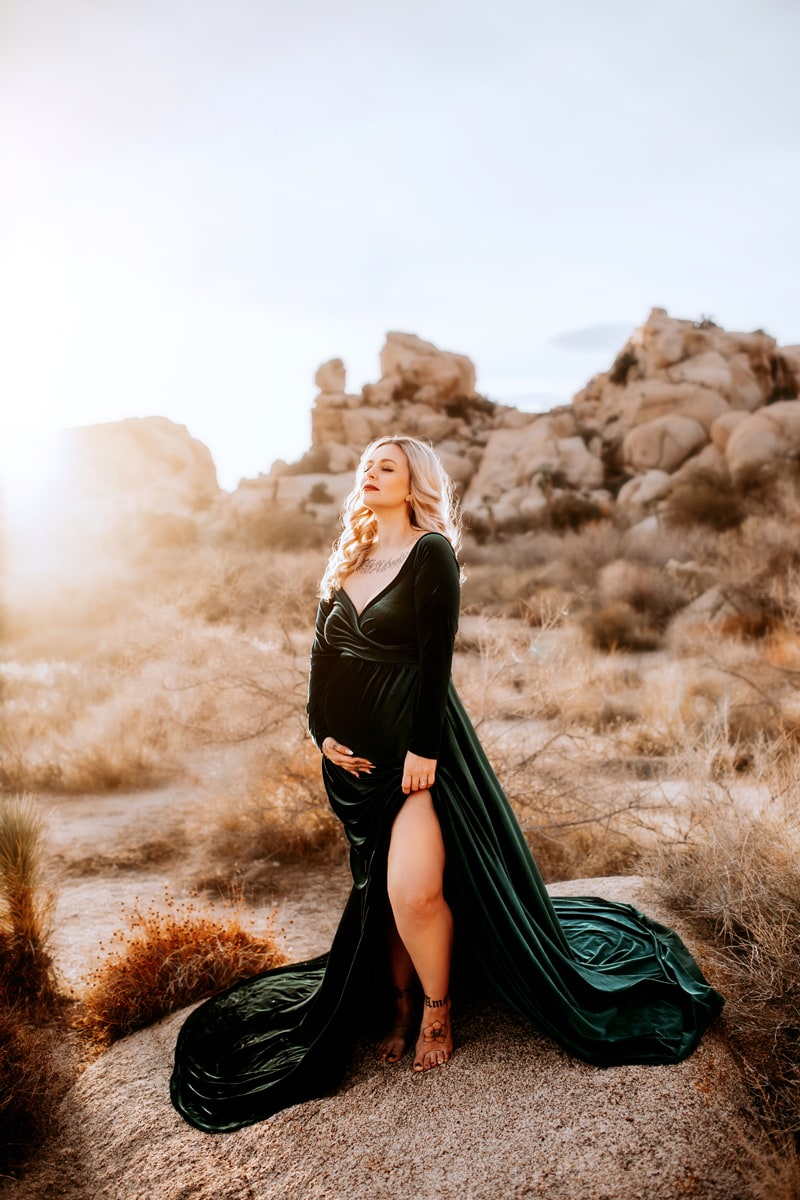Maternity Photographer, an expecting mother in dress stands in the desert