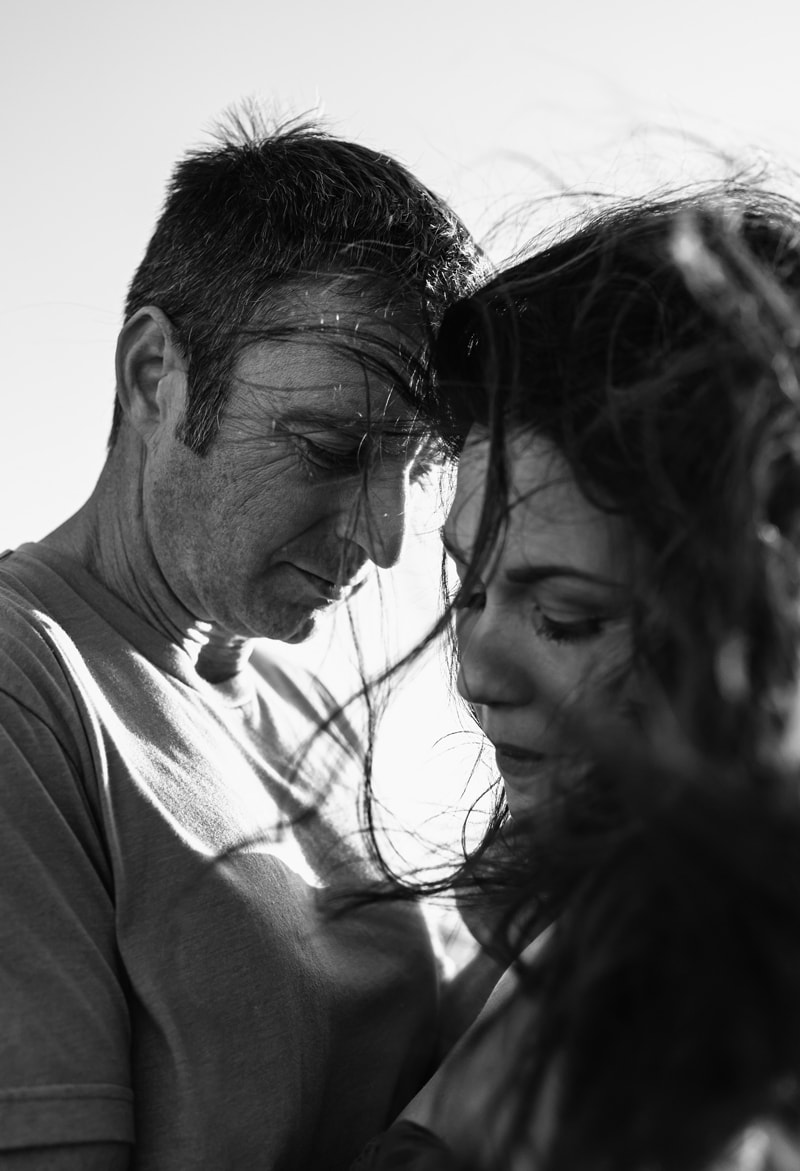 Couples Photographer, man and woman fondly hold each other on a windy day