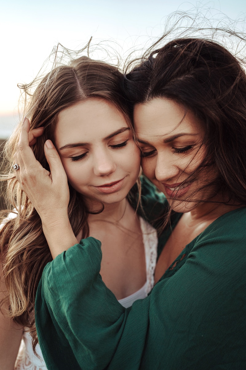 Family Photographer, a mother and young daughter embrace on a windy day