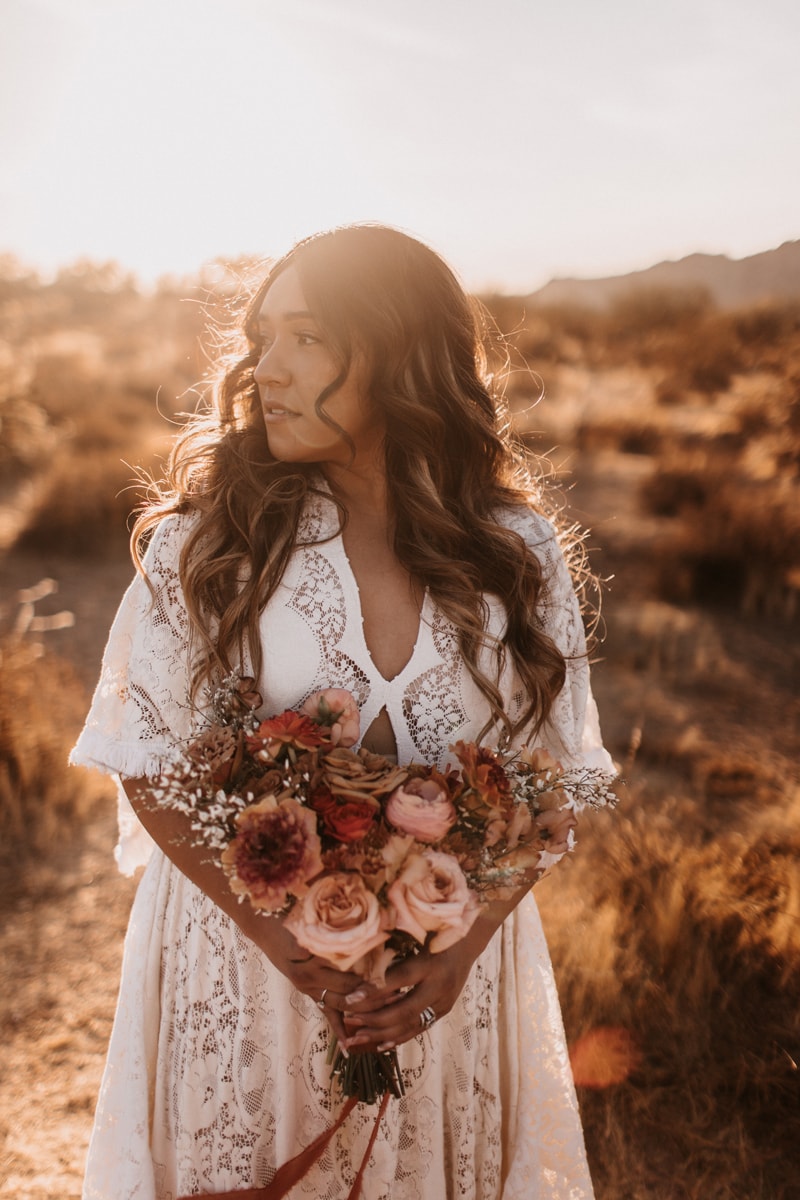 elopement photographer, a bride stand with bouquet on a dry grassy hillside