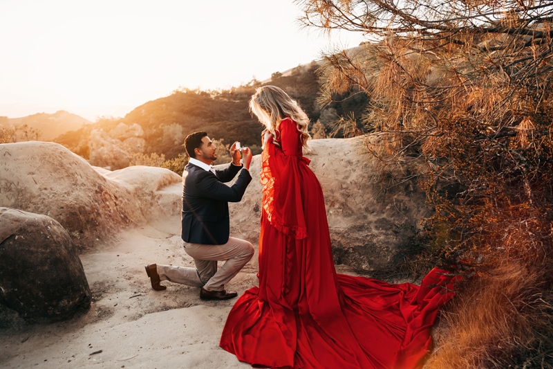 Couples Photographer, man drops to a knee to propose to fiancee on a mountain trail