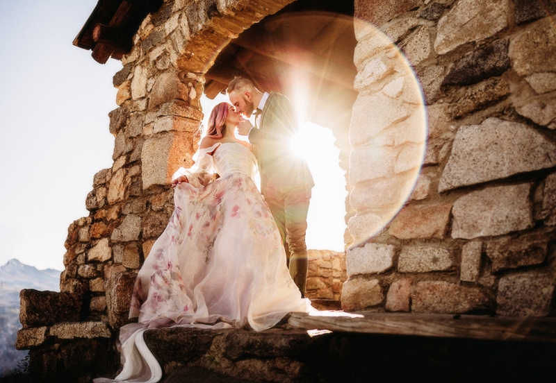 Elopement photographer, bride and groom kiss in a stone structure in the mountains
